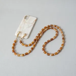 Détail de la chaîne de téléphone en perles acryliques caramel avec fermoirs mousquetons dorés