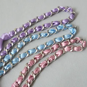 Gros plan sur d'élégantes bandoulières en métal argenté entrelacées de rubans de satin pastel