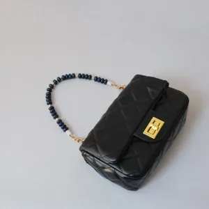 Accessoire de sangle en perles acryliques bleu foncé sur sac matelassé noir