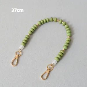 Detailed view of a 37cm green acrylic beaded accessory strap featuring gold lobster clasps