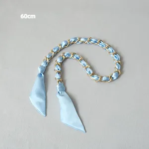 Détail de la bandoulière de 60 cm en soie bleu clair et chaîne en métal doré