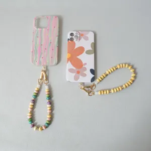 Detail view of colorful acrylic beaded phone straps attached to patterned cases