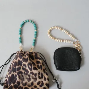 Detail showing acrylic beaded straps in turquoise and white attached to small bags.