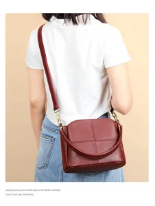 Wine red genuine leather bucket bag detail view showcasing soft texture and shoulder strap.