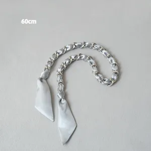 Détail d'une chaîne argentée de 60 cm entrelacée d'un ruban de satin bleu clair.