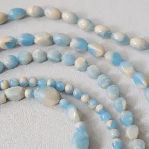 Dettaglio di catena di perle in acrilico marmorizzato blu e bianco per accessori