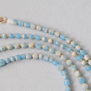 Dettaglio ravvicinato di perle in acrilico azzurro e marmorizzato su catena moda