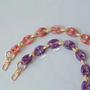 Detailed macro view of purple and pink marble resin bag strap links with dimension markings