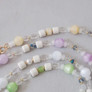 Macro view of colorful pastel acrylic and resin beads on a textured grey background