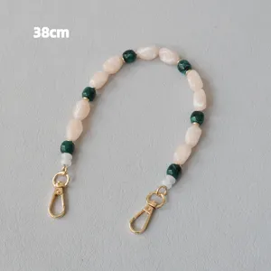 Détail de la bandoulière de sac de 38 cm en perles acryliques crème et vert avec fermoirs dorés