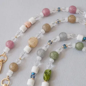 Close-up of colorful glitter acrylic beads and resin stones on a stylish chain strap