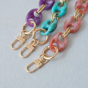 Close-up of retro resin pig-nose chains in purple, turquoise, and pink with gold clasps