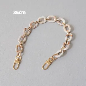 Dettaglio tracolla da 35cm in acrilico marmorizzato beige e metallo dorato per borse