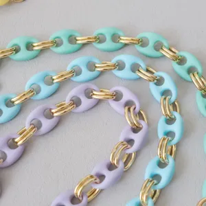 Macro-overzicht van matte zuurstokkleurige acrylkettingen met gouden schakels