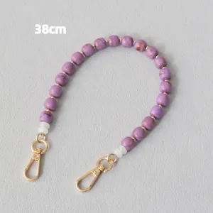 Vista dettagliata di una catena di perle acriliche viola da 38 cm con moschettoni oro.