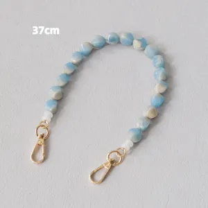 Tracolla in perle acriliche blu marmorizzate con moschettoni dorati, lunghezza 37 cm.