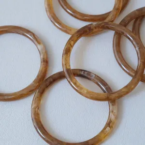 Primer plano de anillas de resina ámbar vintage para joyería DIY y asas de bolsos.