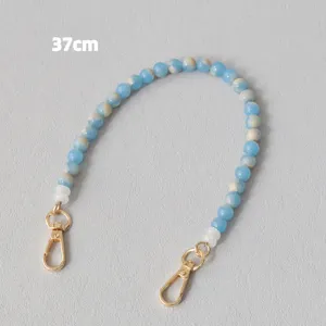 Dettaglio tracolla da 37cm in perle acriliche marmorizzate blu e bianche con ganci