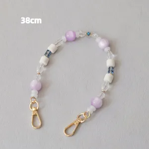 Close-up of a 38cm purple and white acrylic beaded strap with gold clasps