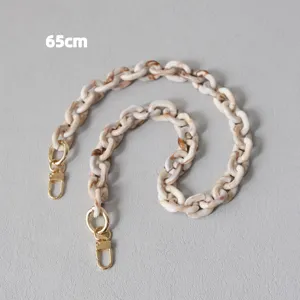 Dettaglio di una catena in resina acrilica beige da 65 cm con moschettoni in metallo dorato.