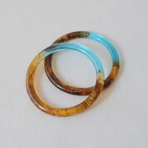 Vista detallada de anillos de resina ámbar y azul vintage para manualidades DIY.