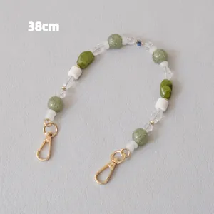 Macro view of 38cm green resin beaded strap featuring gold metal lobster clasps