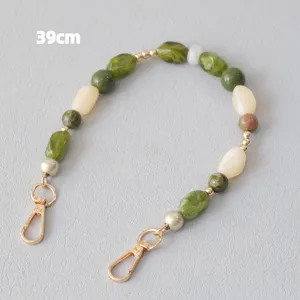 Detailweergave van de 39 cm groene en crème marmeren acryl kralenband met gouden sluitingen