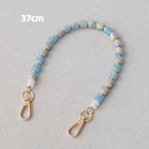 Dettaglio catena di perle acriliche blu e bianche da 37 cm con fermagli a moschettone dorati