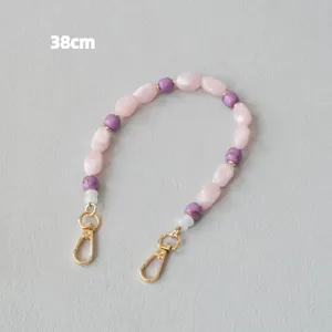 Vue détaillée d'une bandoulière en perles acryliques rose et violette de 38 cm avec fermoirs.