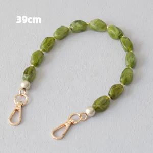 Detailoverzicht van 39 cm groene gemarmerde acryl kralenkettingband met gouden sluitingen