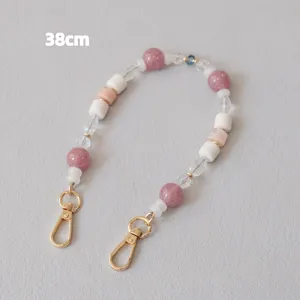Detail view of 38cm beaded bag strap with pink and white acrylic beads and gold clasps.