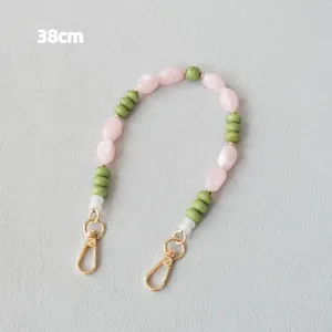 Détail d'une bandoulière en perles acryliques de 38 cm avec perles roses et vertes