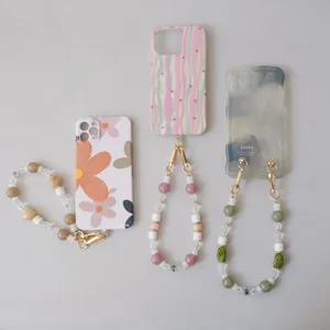 Detail of handmade acrylic beaded phone straps with colorful resin beads and metal clasps.