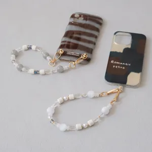 Close-up of elegant acrylic beaded phone straps featuring artistic resin beads and gold hardware