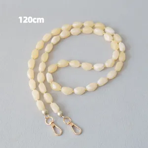 Detailopname van een crème acryl kralenketting met gouden sluitingen, 120 cm lengte