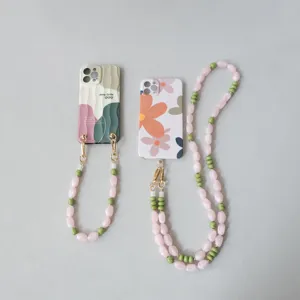 Vue détaillée des dragonnes de téléphone en perles acryliques rose et vert
