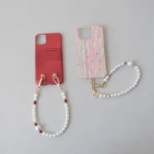Dettaglio di cinturini da polso per telefono in perle e perline di resina colorata con clip d'oro
