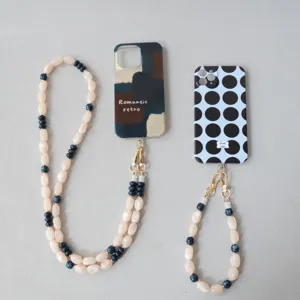 Gros plan de lanières de téléphone en perles acryliques avec des fermoirs dorés en deux tailles.