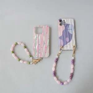 Vue détaillée de lanières de téléphone en perles acryliques avec coques ondulées.