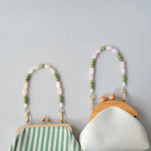Vue rapprochée des poignées élégantes en perles acryliques sur de petits sacs à main.