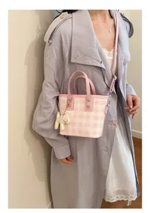Elegant pink and white checkered bucket bag styled with a stylish light purple trench coat