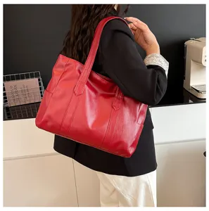 Borsa tote retro in ecopelle rossa indossata da una modella in un ambiente raffinato