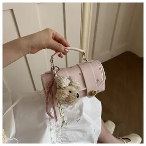 Close-up of pink polka dot pillow bag with cute teddy bear charm and ribbon