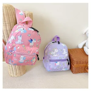 Detail view of pink and purple unicorn backpacks for kids displayed on a stand