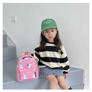 Toddler girl on stairs holding a pink unicorn patterned cute outdoor backpack