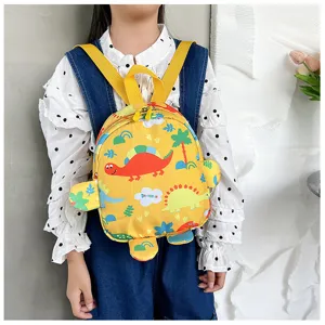 Close-up of a yellow children's backpack featuring cute cartoon dinosaur patterns.
