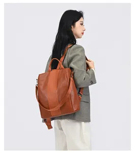 Brauner Damen-Multifunktionsrucksack aus Kunstleder mit Streifendetail am Model