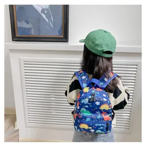 Back view of a child wearing a cute blue dinosaur print backpack in a modern room