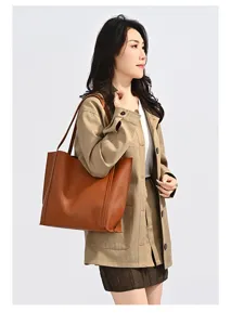 Mannequin asiatique portant un grand sac cabas vintage en cuir marron en studio.
