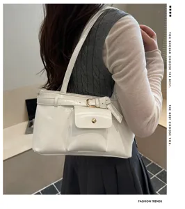 Detailed view of white vintage tote bag with buckle and front pocket worn by a model
